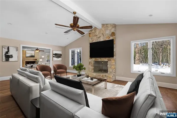 a living room with furniture a flat screen tv and a fireplace