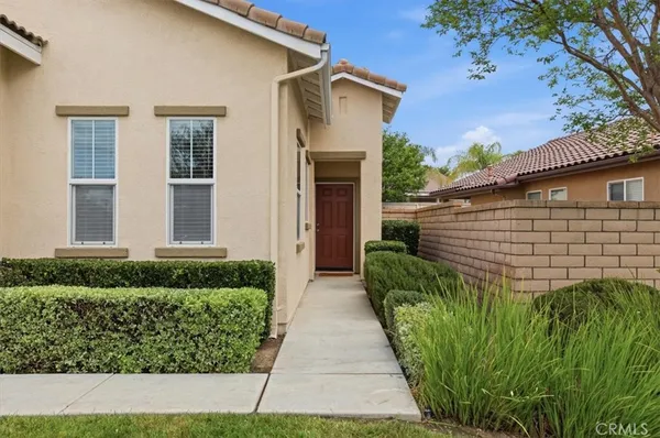a front view of a house with a yard and potted plants