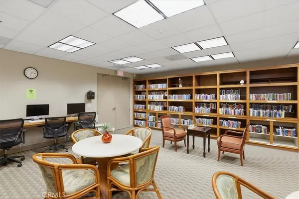 a living room with furniture a rug and a bookshelf