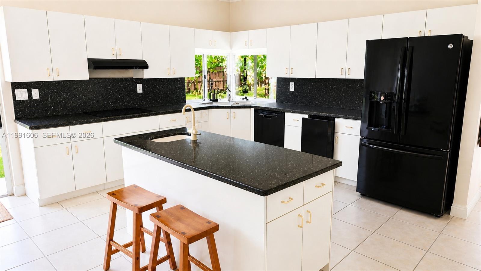 15615 Southwest 42nd Terrace Miami, FL 33185 - Photo 9 of 28 a kitchen with a refrigerator and a sink