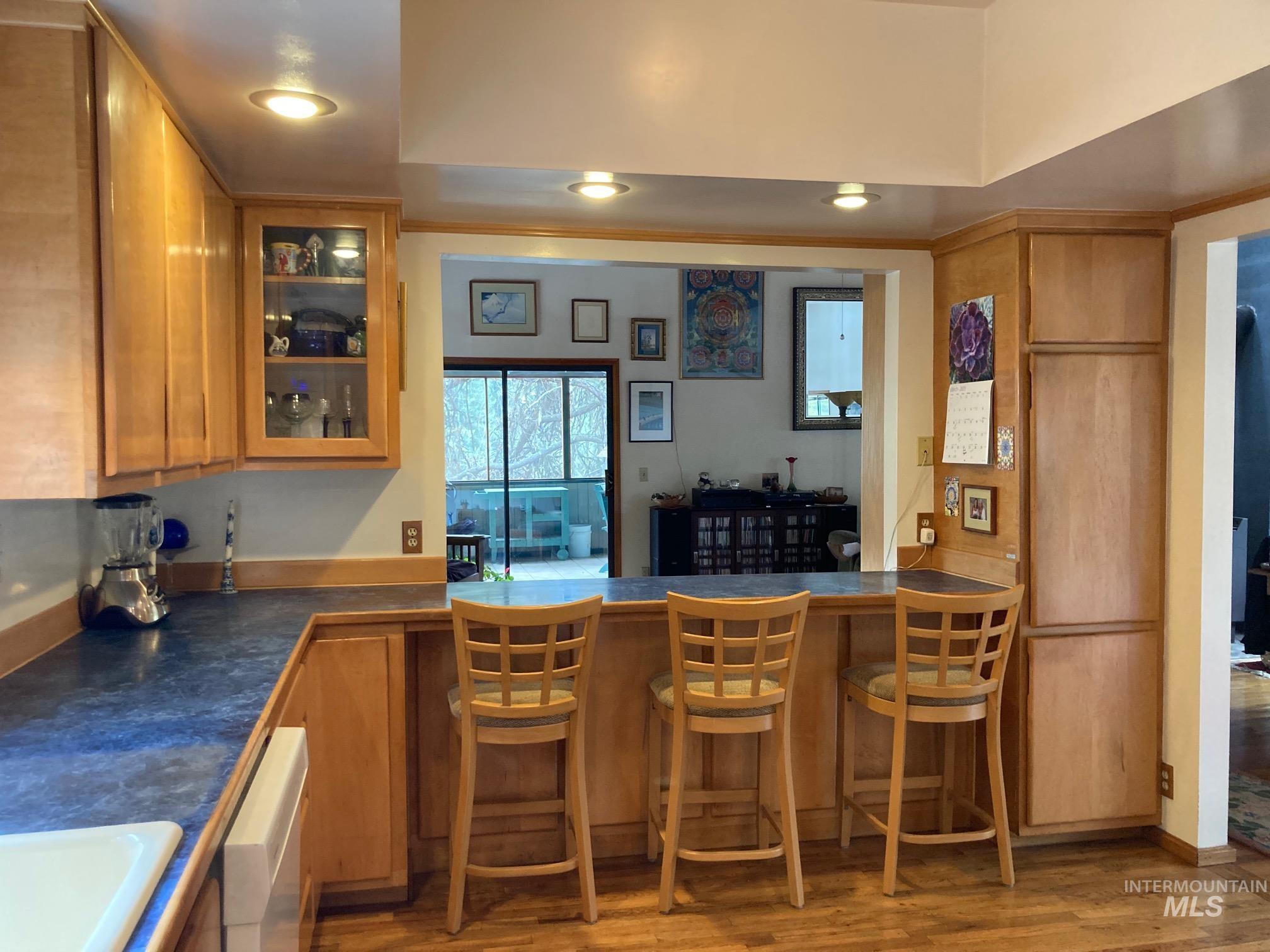 266 Falcon Ridge Road Kooskia, ID 83539 - Photo 11 of 50 Kitchen featuring wood-finish cabinetry, a pass-through counter with seating, recessed lighting, and a dark countertop