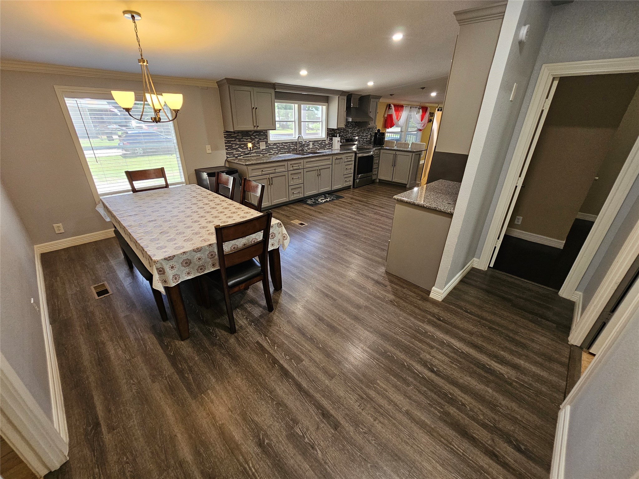 16313 Sandy View Drive Conroe, TX 77303 - Photo 24 of 41 a living room with stainless steel appliances a dining table wooden floor and a fireplace