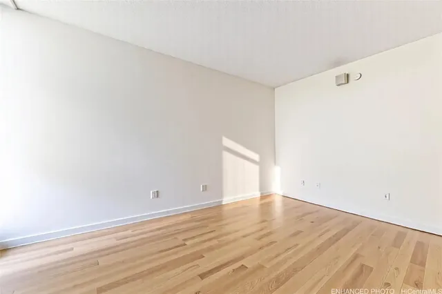 a view of an empty room with wooden floor