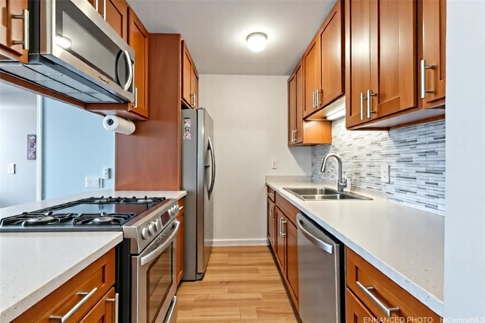 3045 Ala Napuaa Place, Unit 710 Honolulu, HI 96818 - Photo 8 of 25 a kitchen with stainless steel appliances granite countertop a sink a stove and a refrigerator