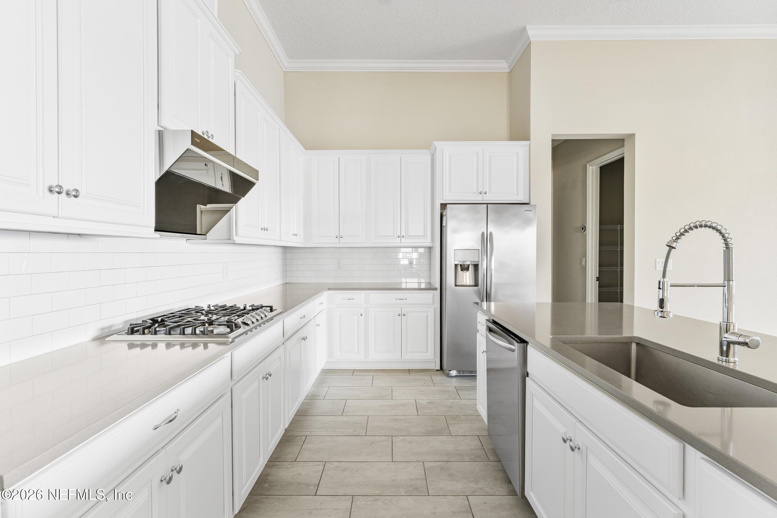 151 Calliel Way St. Johns, FL 32259 - Photo 7 of 35 a kitchen with granite countertop a sink a refrigerator and cabinets