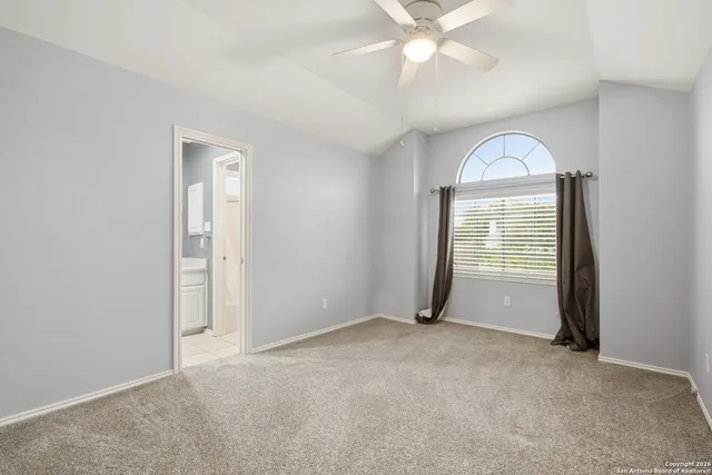 an empty room with fan and windows