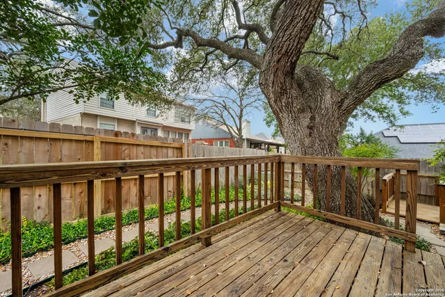 a balcony with wooden floor and trees