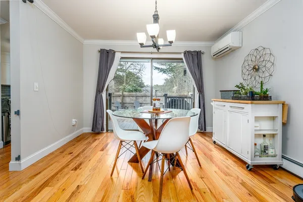 a view of a dining room with furniture a chandelier and wooden floor