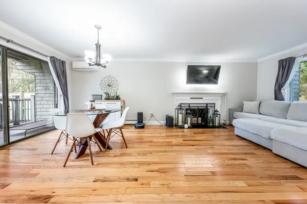a view of a livingroom with furniture wooden floor windows and a fireplace