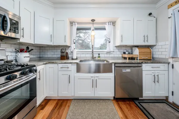 a kitchen with cabinets appliances and a window