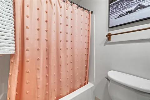 a bedroom with a bed and a dresser next to a window