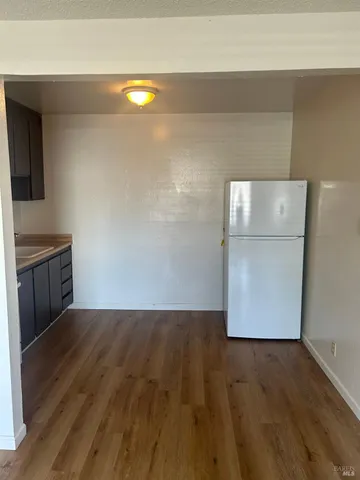 a view of a kitchen with wooden floor and cabinets