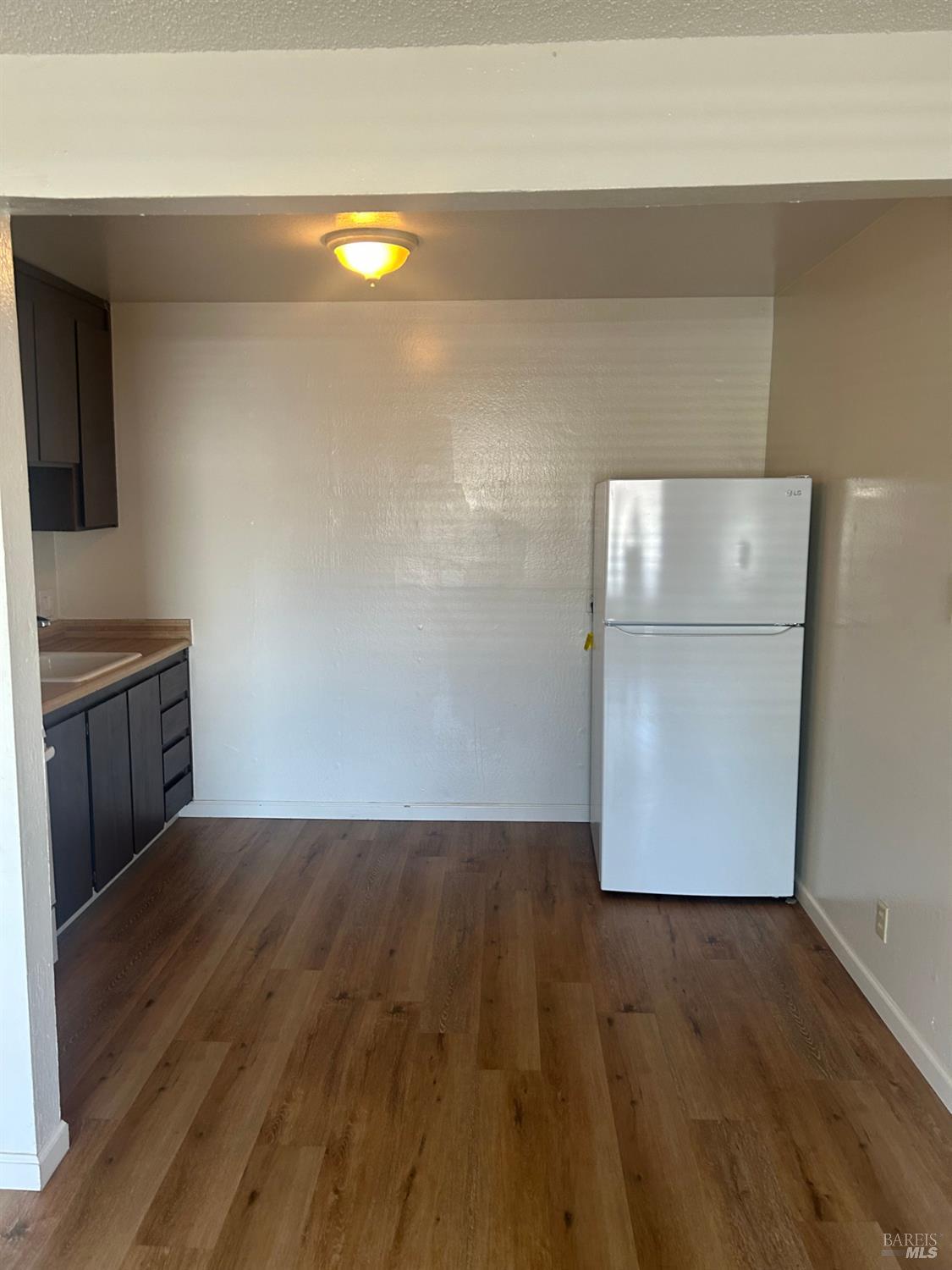 1955 Grande Circle, Unit E Fairfield, CA 94533 - Photo 3 of 9 a view of a kitchen with wooden floor and cabinets