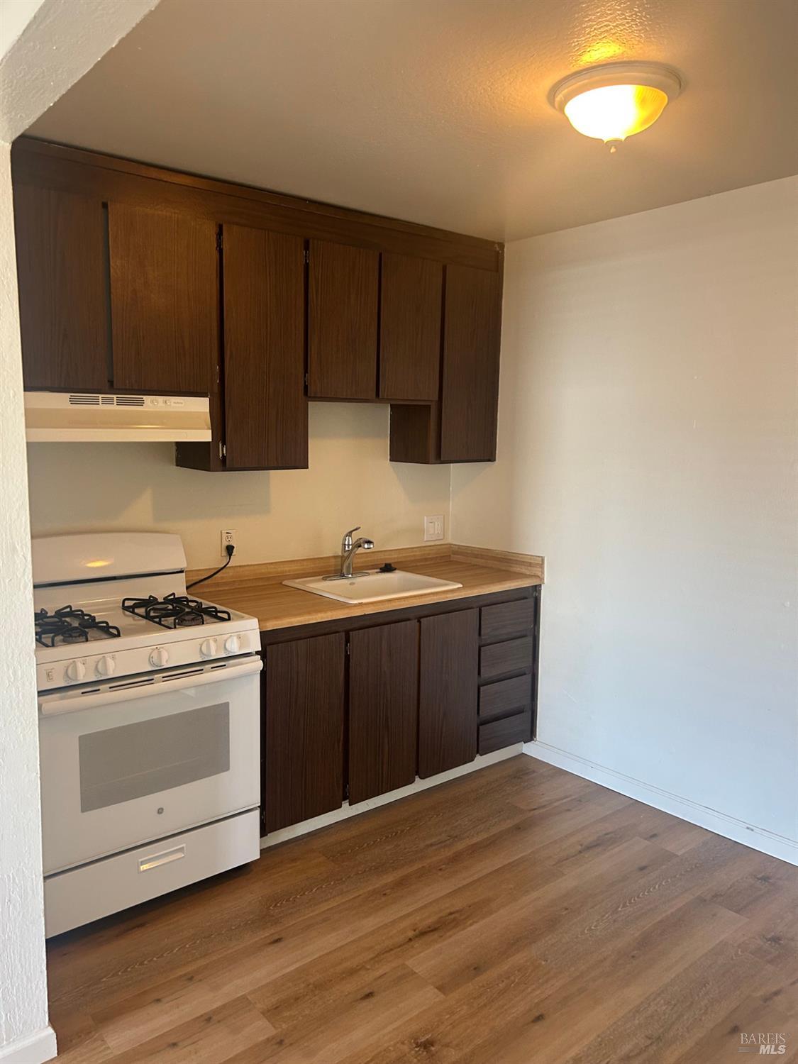 1955 Grande Circle, Unit E Fairfield, CA 94533 - Photo 4 of 9 a kitchen with a stove cabinets and wooden floor