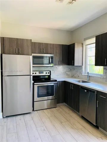 a kitchen with a refrigerator and a stove top oven