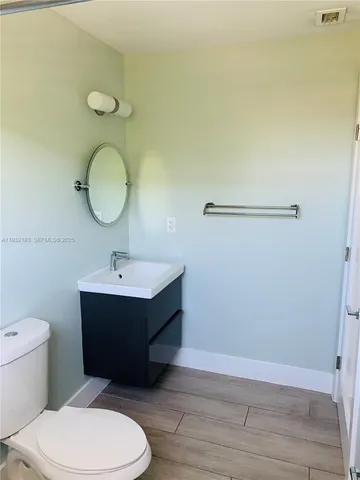 a bathroom with a sink mirror vanity and toilet
