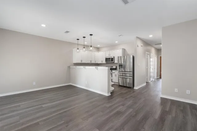 a view of a kitchen with a sink and wooden floor