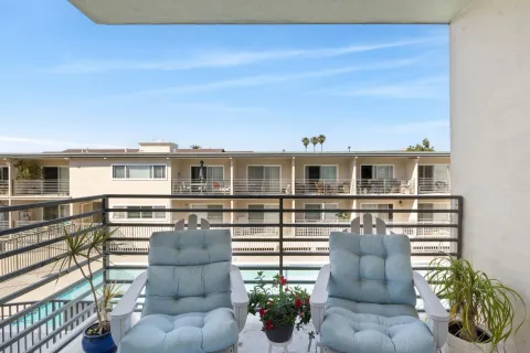 a view of a patio with couches chairs potted plants and wooden floor