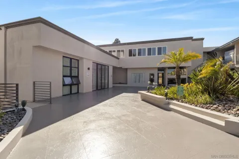 a front view of a house with a yard and potted plants