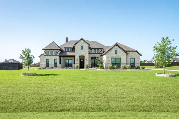 a view of a house with a big yard and large trees