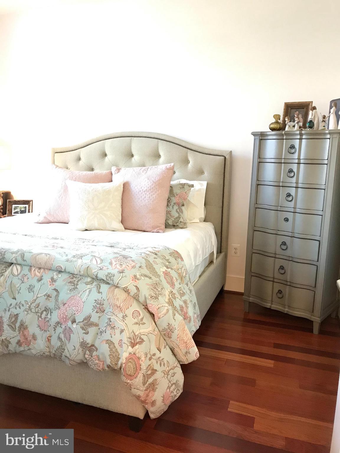 4301 Military Road Northwest, Unit 208 Washington, DC 20015 - Photo 13 of 32 a large bed sitting in a bedroom next to a wooden floor