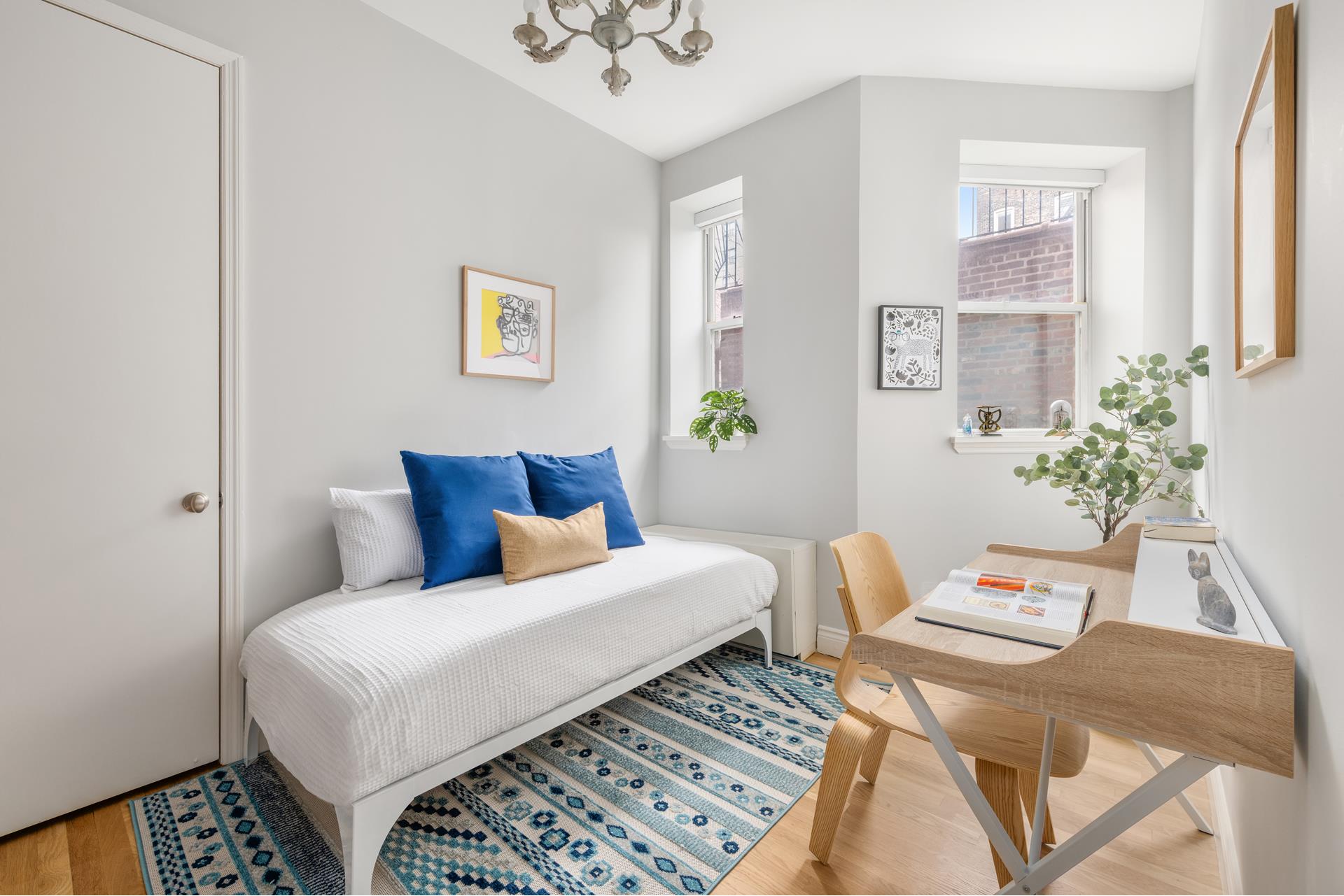 229 West 116th Street, Unit 2B Manhattan, NY 10026 - Photo 10 of 18 a bedroom with a bed and a table