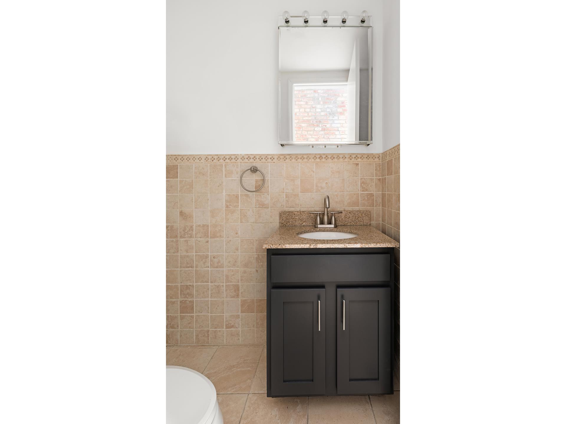 229 West 116th Street, Unit 2B Manhattan, NY 10026 - Photo 11 of 18 a bathroom with a sink and a mirror