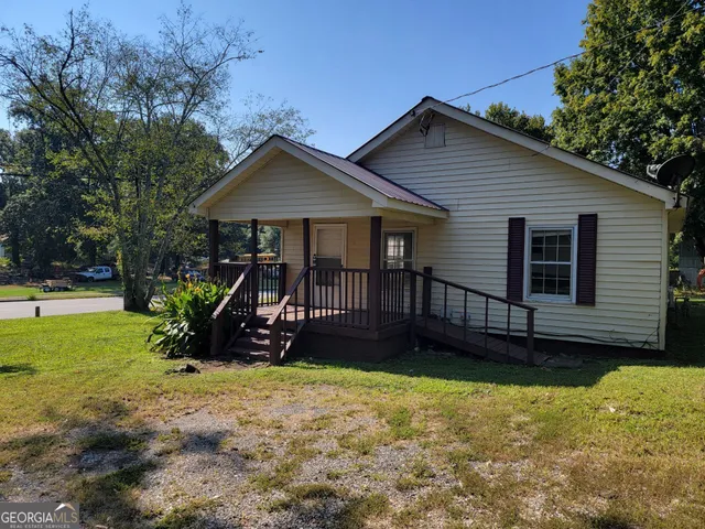 a view of a house with a yard and sitting area