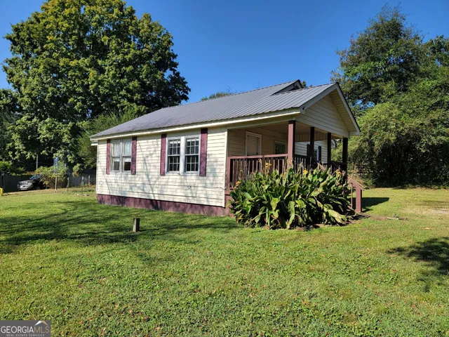 a view of a house with a yard and sitting area