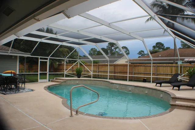 a view of a house with swimming pool and sitting area