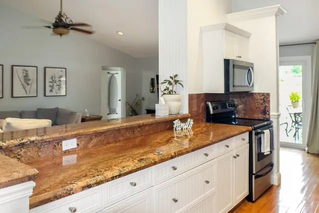 a kitchen with granite countertop white cabinets and a sink