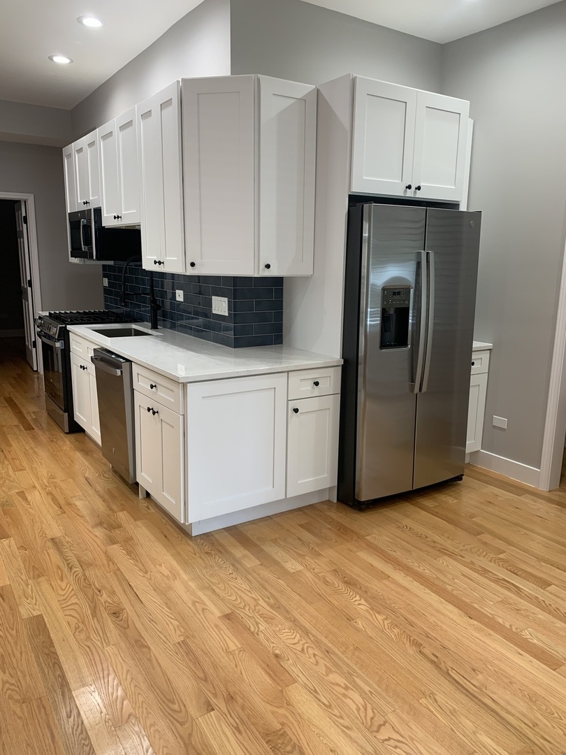 1303 West Flournoy Street, Unit 1F Chicago, IL 60607 - Photo 3 of 15 a kitchen with stainless steel appliances a refrigerator sink and microwave