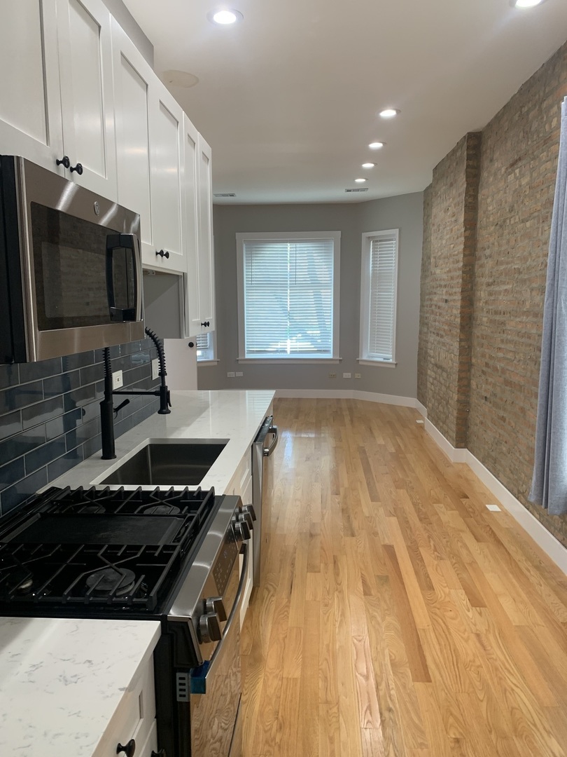 1303 West Flournoy Street, Unit 1F Chicago, IL 60607 - Photo 6 of 15 a kitchen with a stove a sink and a microwave