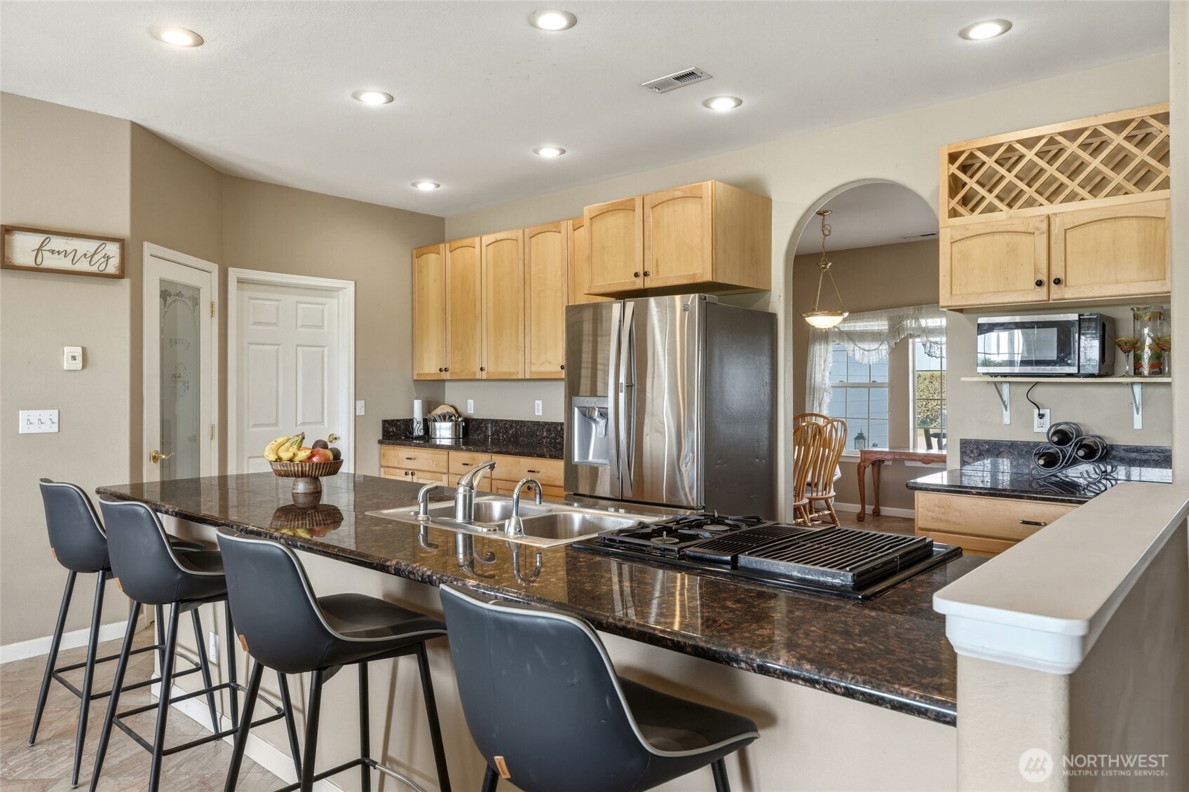 219 Reeds Road Touchet, WA 99360 - Photo 12 of 40 a kitchen with stainless steel appliances granite countertop a stove a refrigerator a kitchen island with white cabinets and couches