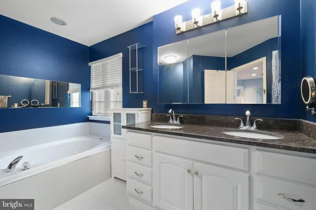 a bathroom with a granite countertop sink mirror and bathtub