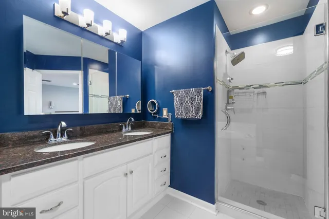 a bathroom with a double vanity sink mirror and shower