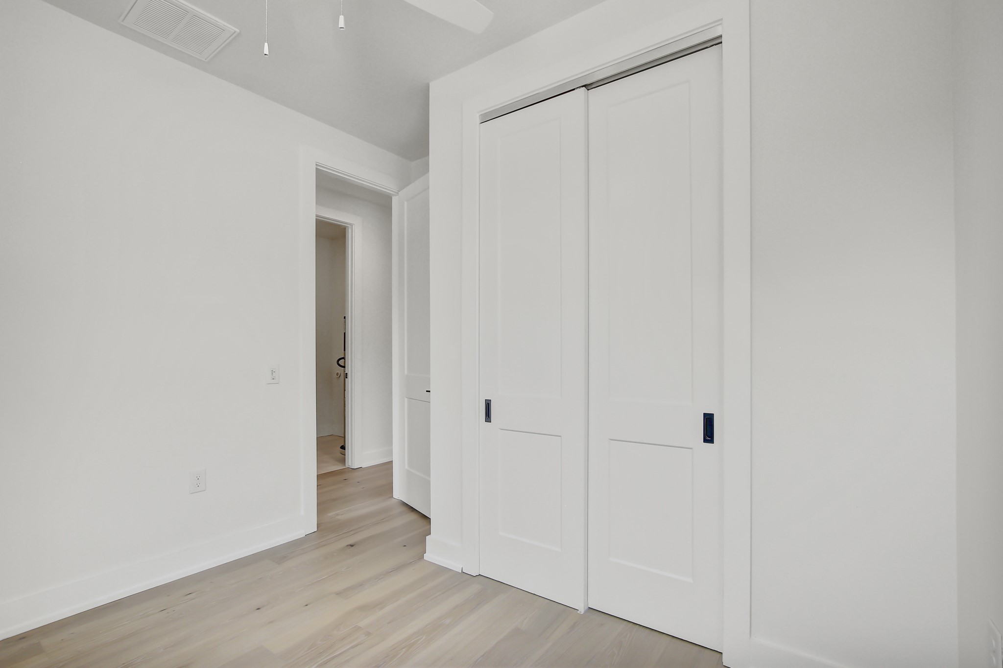 4127 East 12th Street, Unit 8 Austin, TX 78721 - Photo 23 of 32 Unfurnished bedroom featuring light wood finished floors, a closet, and baseboards