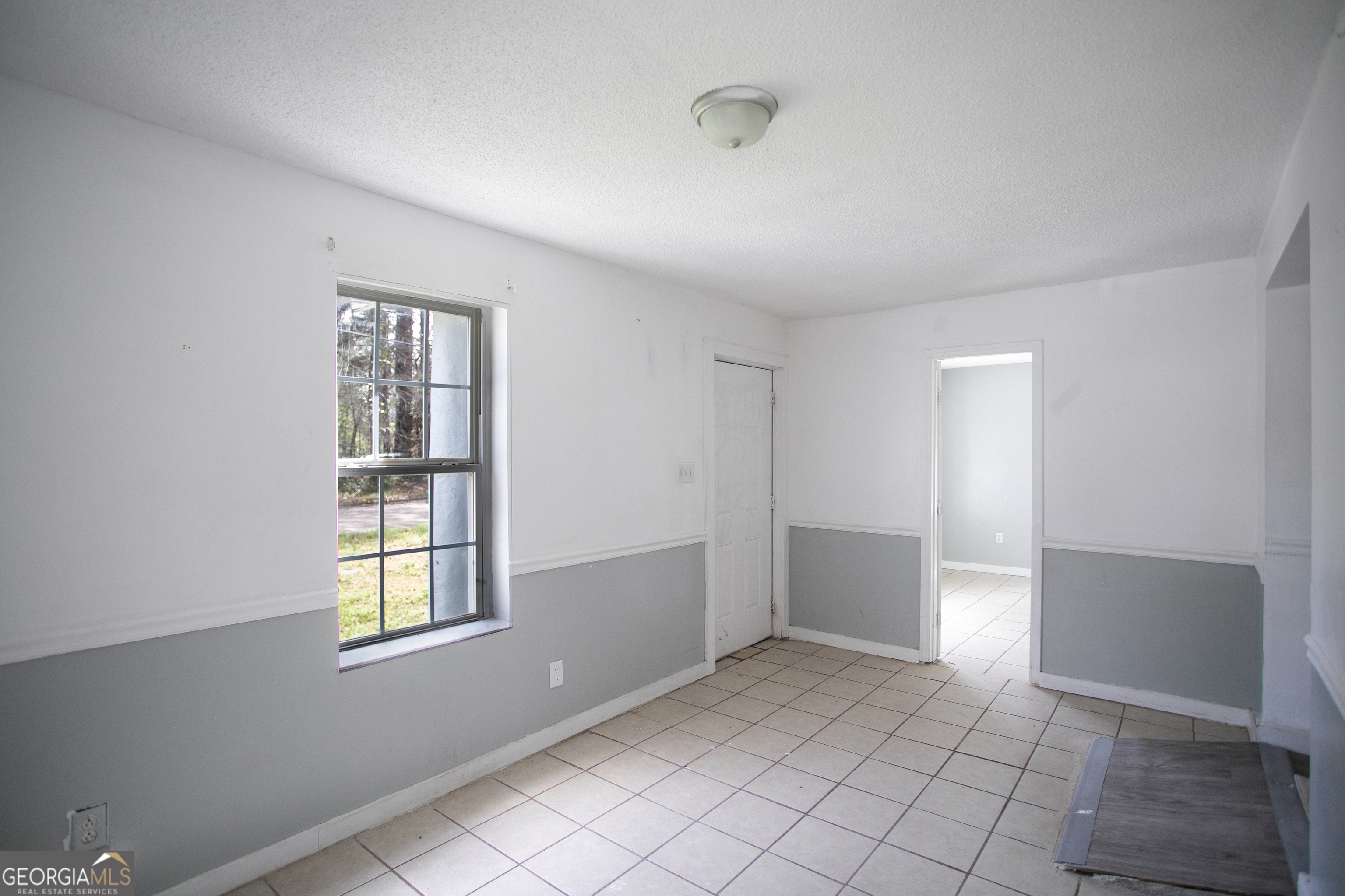 402 Boulevard Street Fort Valley, GA 31030 - Photo 3 of 10 a view of an empty room with window and chandelier fan