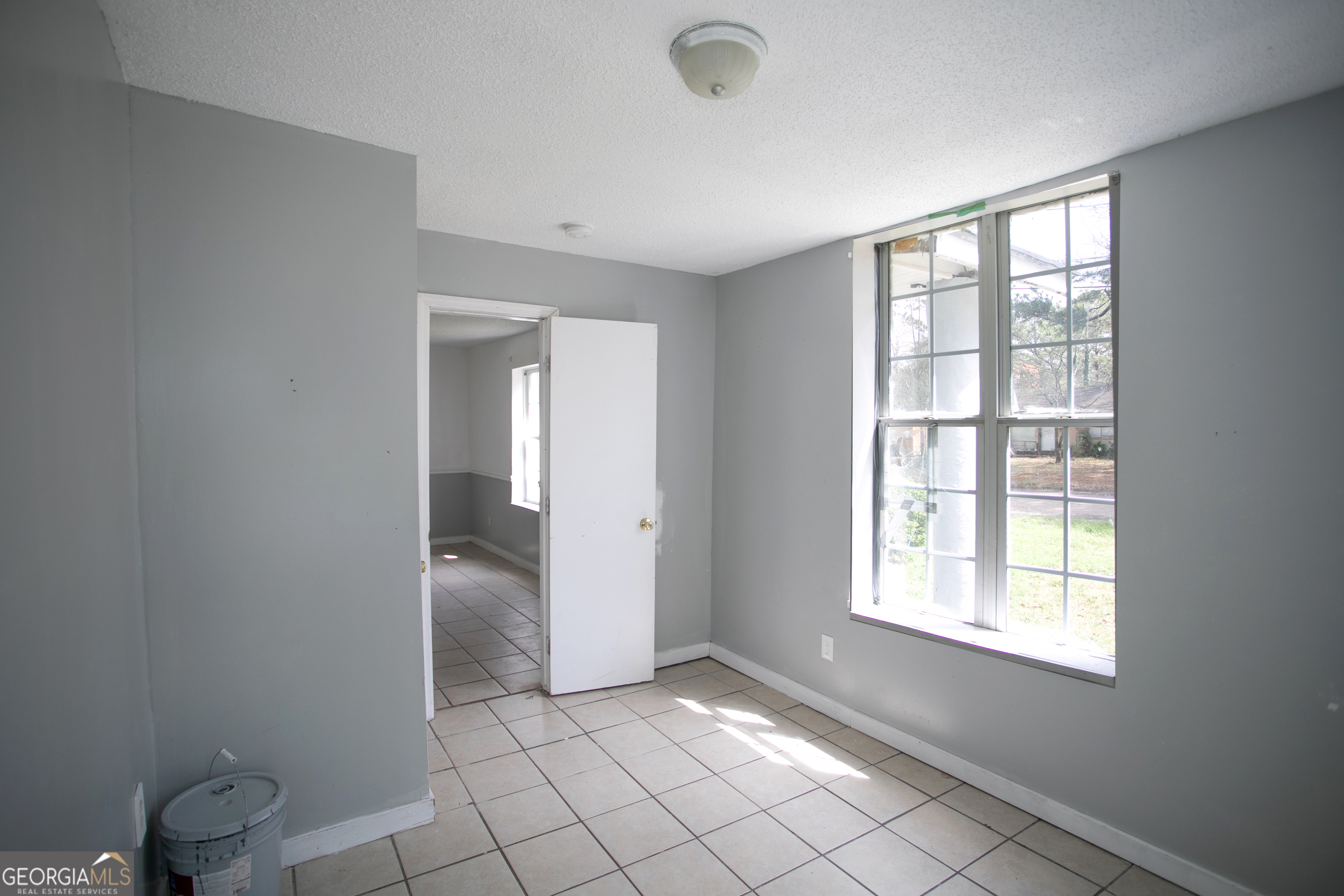 402 Boulevard Street Fort Valley, GA 31030 - Photo 4 of 10 a view of an empty room with window and chandelier fan