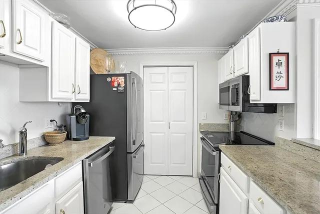a view of a kitchen with kitchen island a sink stainless steel appliances wooden floor and a counter top space