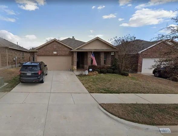 a front view of a house with cars parked