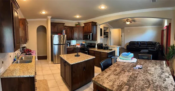a large kitchen with stainless steel appliances kitchen island granite countertop a sink and cabinets