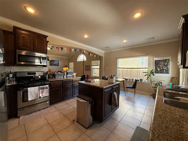 a kitchen with stainless steel appliances granite countertop a stove top oven a sink dishwasher and cabinets