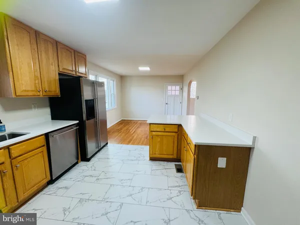 a kitchen with stainless steel appliances granite countertop a refrigerator a stove top oven and cabinets