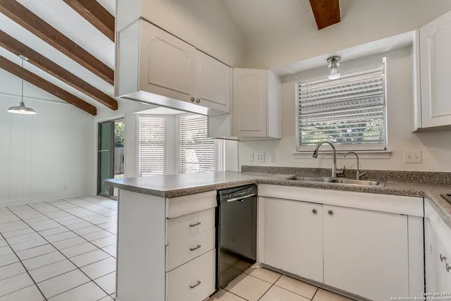a kitchen with granite countertop a sink stainless steel appliances and cabinets