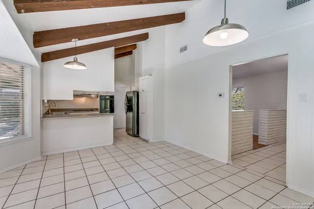a kitchen with a refrigerator and white cabinets