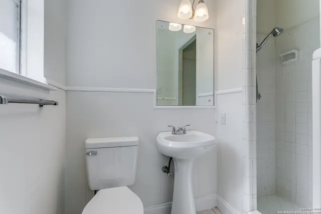 a bathroom with a toilet sink and mirror