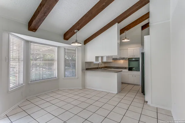 a kitchen with granite countertop a sink and white cabinets