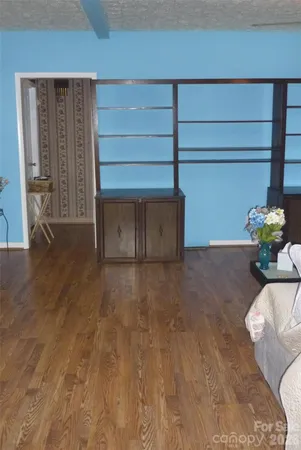 a view of an empty room with wooden floor and a cabinet