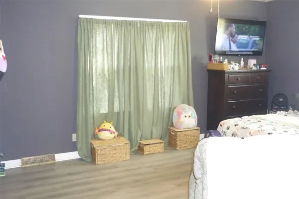 a bedroom with bed and wooden floor